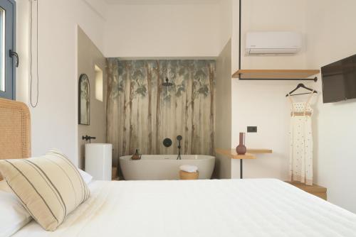 a bedroom with a white bed and a bath tub at Pelagias Loft Villas Heated pool in Kavros