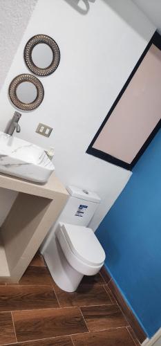 a bathroom with a white toilet and a sink at Diseño lindo in San Baltasar