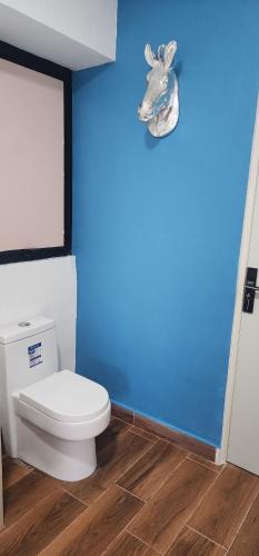 a bathroom with a toilet and a blue wall at Diseño lindo in San Baltasar