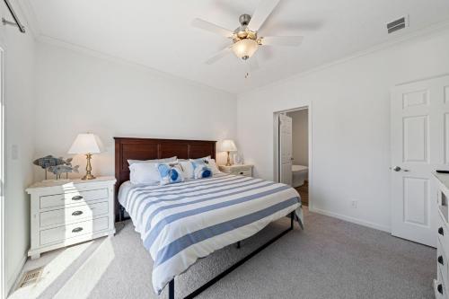 a white bedroom with a bed and a ceiling fan at Lake Erie Serenity Hutch in Port Clinton