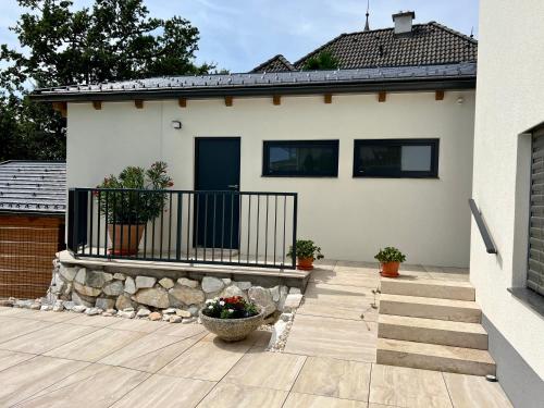 a white house with a porch and a fence at Apartments Sunnseitn by Gerrit & Herfried in Krumpendorf am Wörthersee