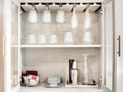 a shelf with glass bottles and vases on it at Bubbles in the Sand in Tybee Island