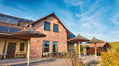 NagyvelegVelegi Kaland Tanya的前面有太阳能电池板和遮阳伞的房子