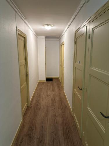 - un couloir vide avec des portes et du parquet dans l'établissement STUDIO proche commodité et gare . Centre ville, à Caen