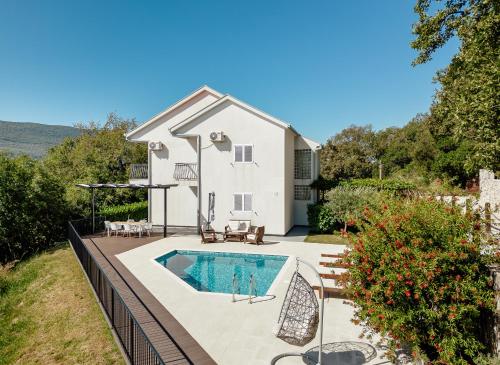a house with a swimming pool in the backyard at Villa Sladovic in Herceg-Novi