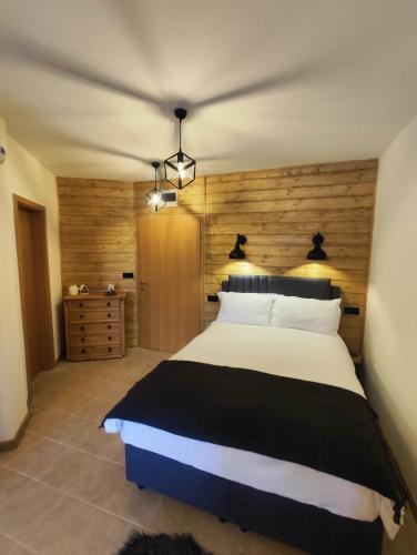 a bedroom with a large bed with a wooden wall at Aspen Resort Studio I306 in Razlog