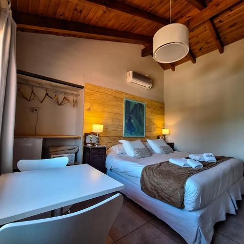 a hotel room with two beds and a table at Hotel Antiguo Camino in Villa General Belgrano