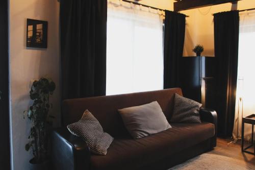 a brown couch with pillows in a living room at TheAttic in Corbeni