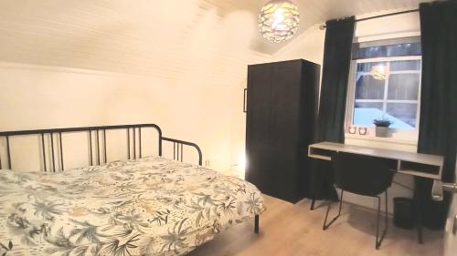 a bedroom with a bed and a desk and a window at Stunning Sleeps 9 Lakeview Loghome Spa & Yoga in Finnerödja