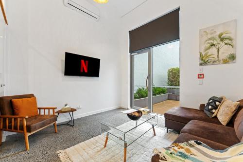 a living room with a n on the wall at Loft Retreat in Auckland