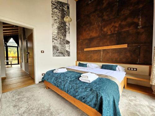 a bedroom with a large bed with a wooden headboard at ChaletSKI Jasná, SKI-IN & SKI-OUT in Demanovska Dolina