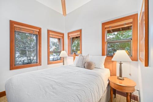 a bedroom with a white bed and two windows at Montebello by Whistler Premier in Whistler