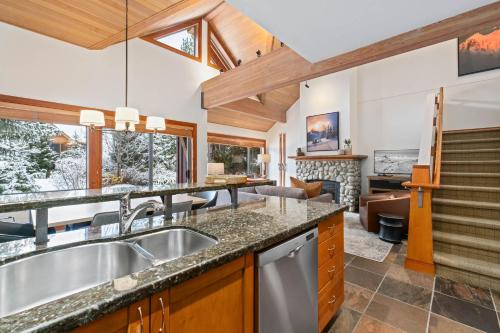 a kitchen with a sink and a living room at Montebello by Whistler Premier in Whistler