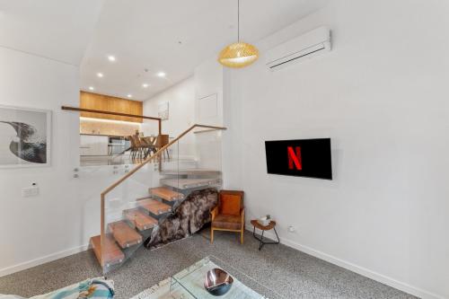 a living room with a spiral staircase in a house at Loft Retreat in Auckland