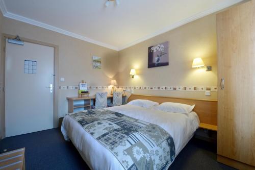 Cette chambre comprend un grand lit et un bureau. dans l'établissement Hotel Le Bellevue, à Saint-Hippolyte