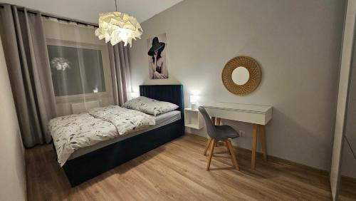 a small bedroom with a bed and a desk at Apartamenty Września IV in Września