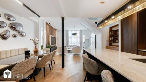 une cuisine et une salle à manger avec une grande table et des chaises dans l'établissement Maison de Luxe à 500m de la gare, à Courbevoie
