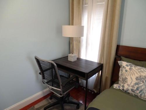 a desk with a lamp and a chair next to a bed at Spacious Two Bedroom Apartment in Wayland