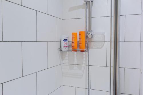 a bathroom with white tiled walls and a shower stall at Chic 4 Bed by Brighton Station in Brighton & Hove