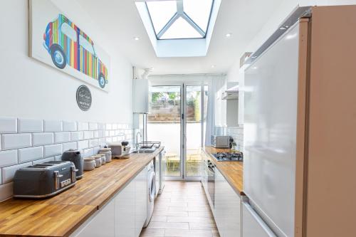 a kitchen with white walls and a skylight at Chic 4 Bed by Brighton Station in Brighton & Hove
