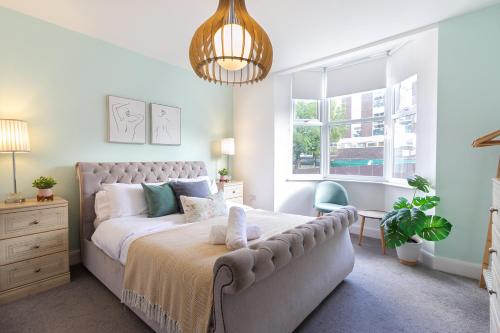 a bedroom with a bed and a large window at Chic 4 Bed by Brighton Station in Brighton & Hove