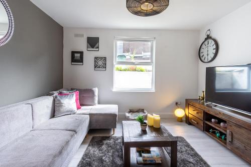 a living room with a couch and a tv at Chic 4 Bed by Brighton Station in Brighton & Hove