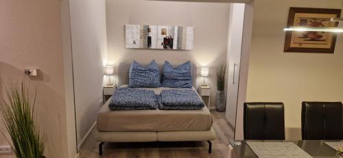 a room with a bed with blue pillows on it at Panorama Eifel View in Nideggen
