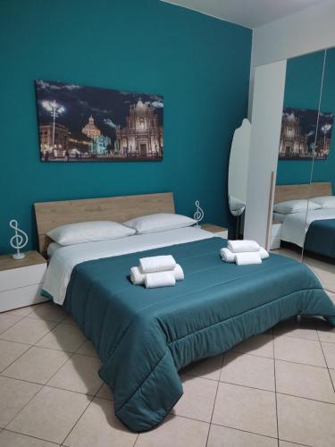 a bedroom with a large bed with blue walls at Kamurria House in Catania