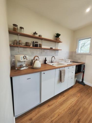 a kitchen with white cabinets and a sink at Le Bel Abri in Boulleville