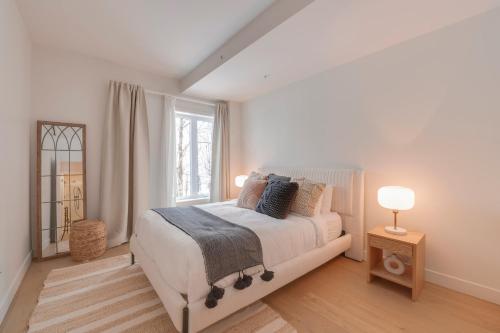 una camera da letto bianca con un letto e una finestra di La Libériste 108 - Ski-in Ski-out - 4 personnes a Beaupré