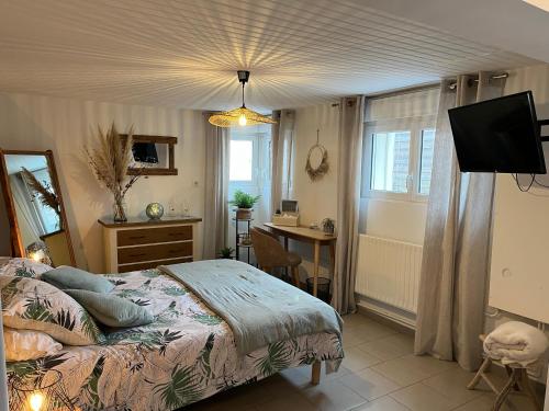une chambre avec un lit, un bureau et une télévision dans l'établissement La Rose des Vents, au Crotoy