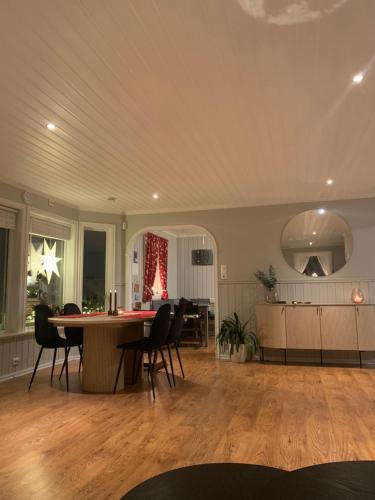 a living room with a dining room table and chairs at Tromsø - seksjonert hus i nydelige omgivelser in Trondalen