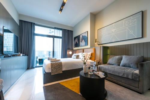 a hotel room with a bed and a couch at Canal View Studio Downtown - Near Dubai Mall & Burj Khalifa - MAG 318 in Dubai