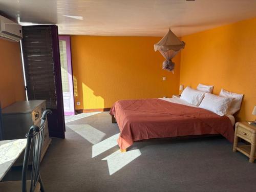 a bedroom with a bed and a yellow wall at Filaos Loft in Fort-de-France