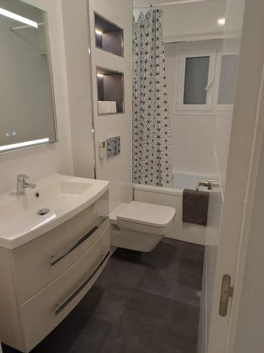 a white bathroom with a sink and a toilet at Alice Home in Puebla de Farnals