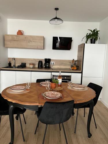 Il comprend une cuisine avec une table en bois et 4 chaises. dans l'établissement Appartement Vannes Odyssée, à Vannes