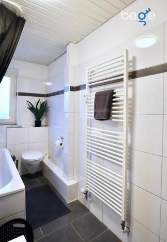 a white bathroom with a toilet and a sink at BEGE APARTMENTS WorkLodge in Duisburg