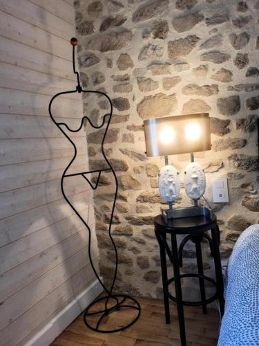 a lamp on a table next to a bed at Gîte de France Gîte bournabas 4 épis - Gîte de France 8 personnes MAE-6491 in Les Bournas