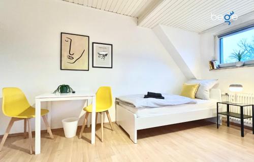 a bedroom with a bed and a desk and chairs at BEGE APARTMENTS WorkLodge in Duisburg