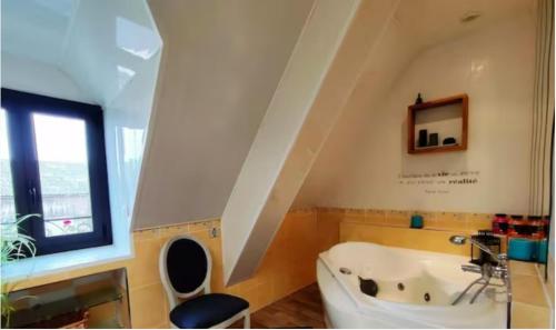 a bathroom with a white tub and a window at Gite de la Fauvelière in Touffreville-la-Corbeline