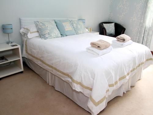 a bedroom with a large white bed with towels on it at Westacre Bed & Breakfast in Crieff