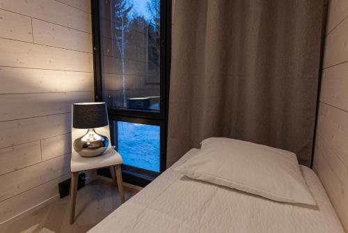 a bedroom with a bed and a lamp on a chair at Vuokatti Weekend Platinum I in Vuokatti