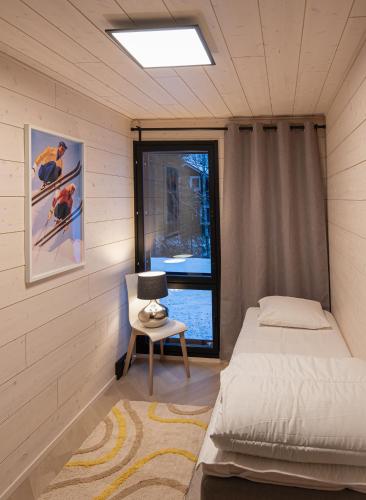 a bedroom with a bed and a chair and a window at Vuokatti Weekend Platinum I in Vuokatti