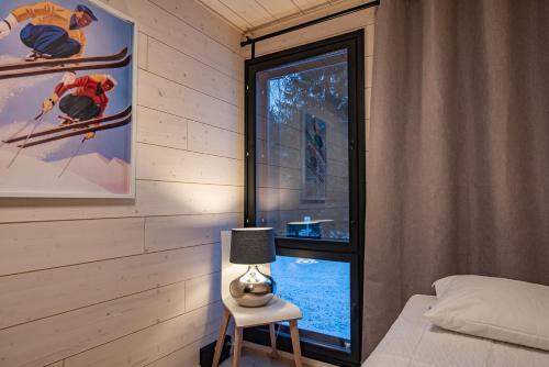 a bedroom with a bed and a lamp next to a window at Vuokatti Weekend Platinum I in Vuokatti