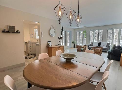 a dining room and living room with a table and chairs at The Sunny Paradise in Mont-Tremblant