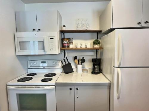 a kitchen with a white stove and a white refrigerator at The Sunny Paradise in Mont-Tremblant