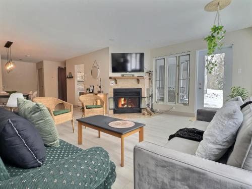 a living room with a couch and a fireplace at The Sunny Paradise in Mont-Tremblant