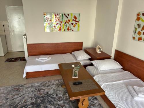 a room with two beds and a table and a couch at Ourania's Apartment Kastoria in Mavrokhórion