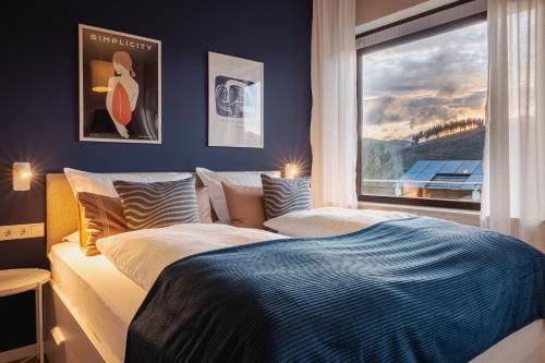 a bedroom with two beds and a window at Design-FeWo Sonnendeck in Winterberg