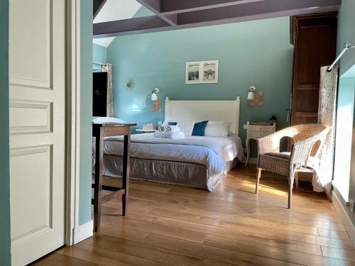 a bedroom with a bed and a chair at Fleur & Mer in Montfarville